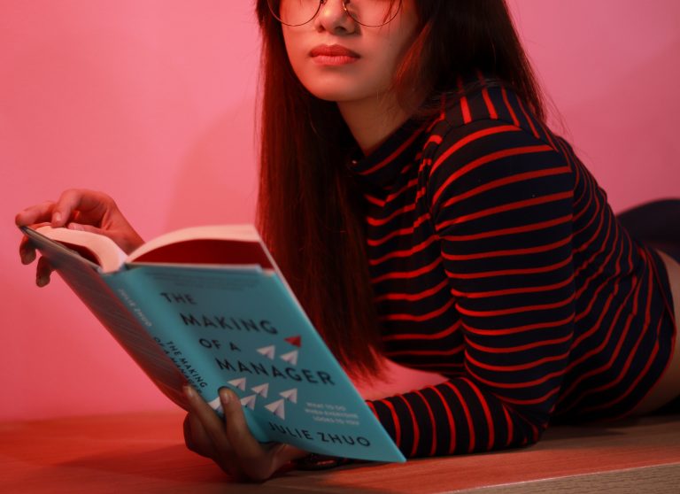 cuentacuentos, firmas y presentaciones de febrero, representados por una joven leyendo con fondo rosa